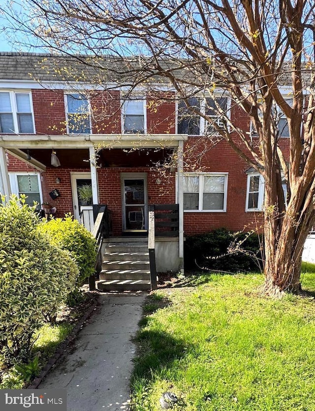 7437 Berkshire Rd, Baltimore, MD 21224 - view of front facade featuring brick siding, a front yard, and covered porch