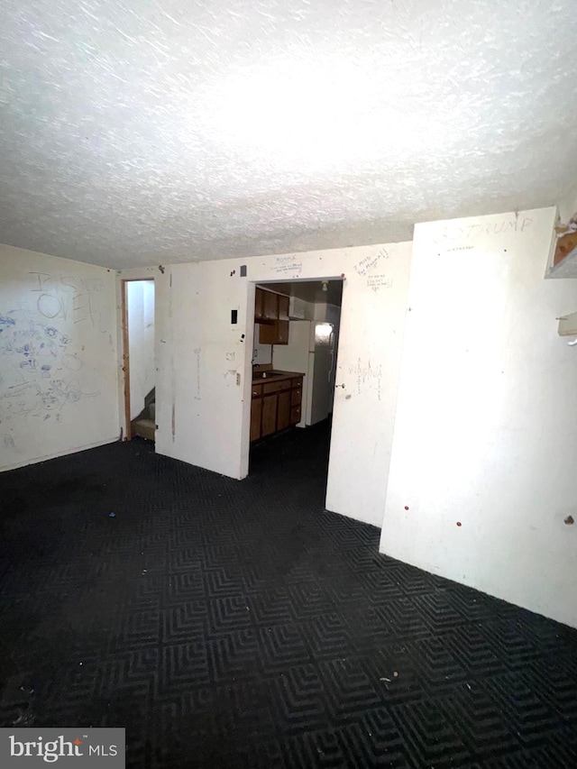 7437 Berkshire Rd, Baltimore, MD 21224 - empty room featuring stairway, a textured ceiling, dark colored carpet, and a sink