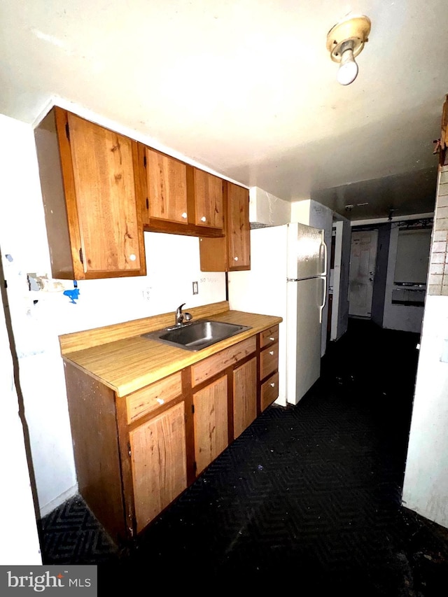 7437 Berkshire Rd, Baltimore, MD 21224 - kitchen with a sink, brown cabinetry, light countertops, and freestanding refrigerator
