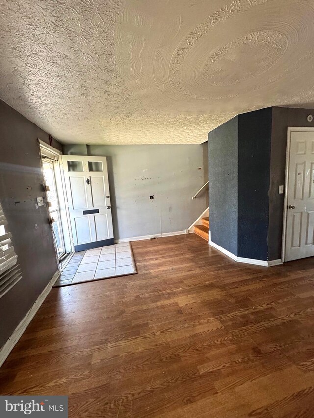 7437 Berkshire Rd, Baltimore, MD 21224 - entrance foyer featuring a textured ceiling, wood finished floors, stairway, and baseboards