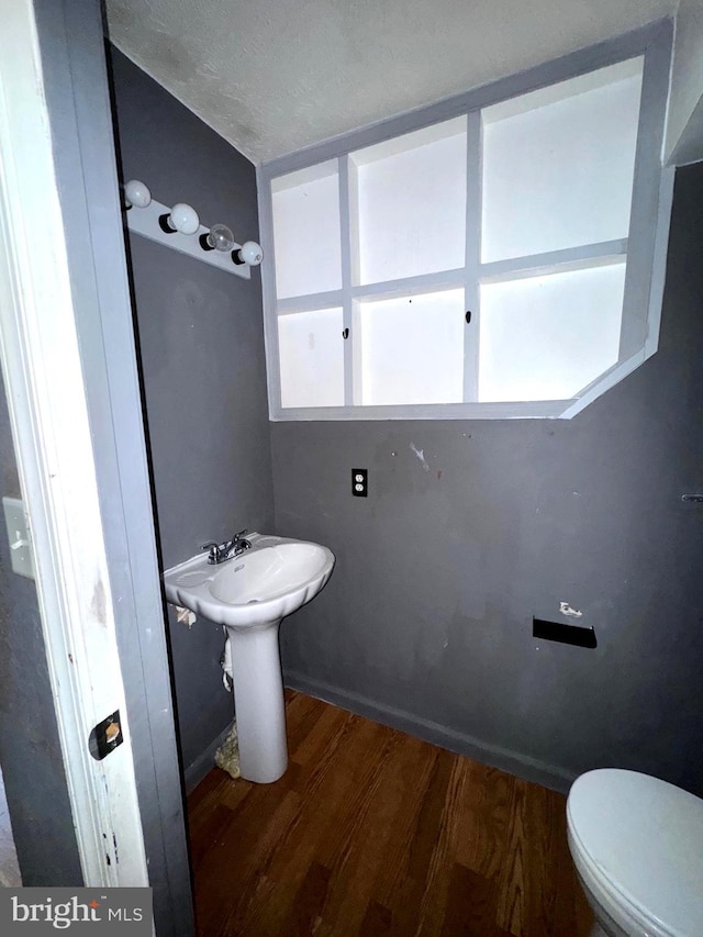 7437 Berkshire Rd, Baltimore, MD 21224 - bathroom featuring wood finished floors, toilet, and healthy amount of natural light