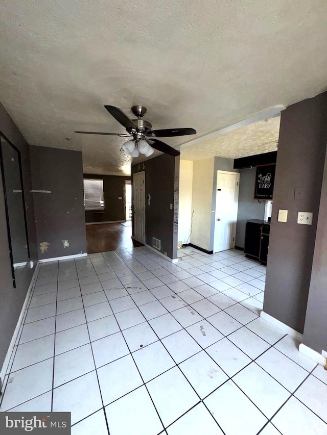 7437 Berkshire Rd, Baltimore, MD 21224 - unfurnished living room featuring ceiling fan, baseboards, a textured ceiling, and light tile patterned floors