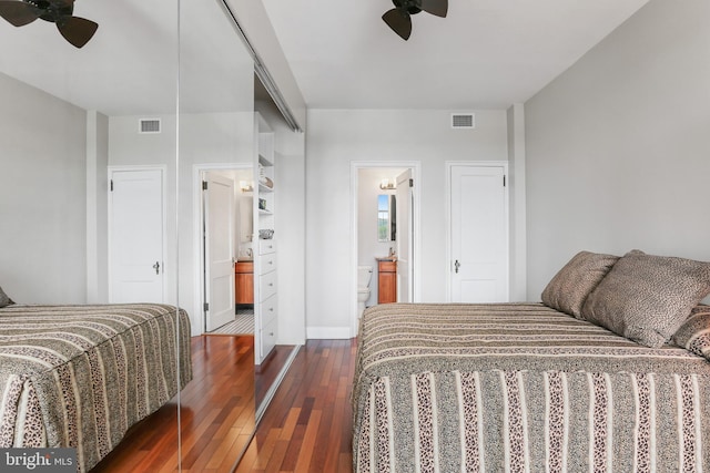 bedroom with dark wood-style floors, ceiling fan, ensuite bathroom, and visible vents