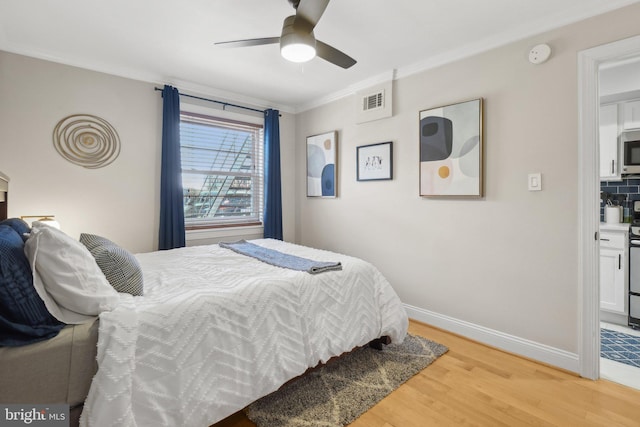 bedroom featuring a ceiling fan, crown molding, light wood-style floors, baseboards, and visible vents