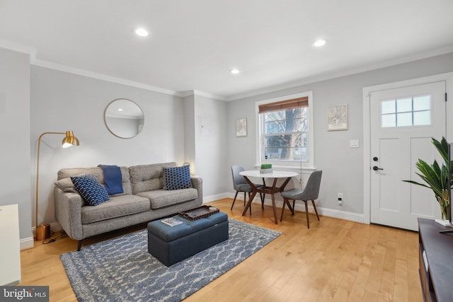 living room with recessed lighting, a healthy amount of sunlight, crown molding, and light wood-style flooring