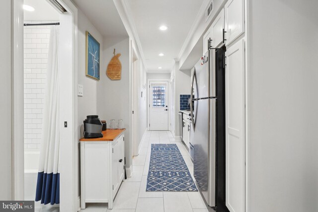 hallway featuring light tile patterned floors, baseboards, ornamental molding, visible vents, and recessed lighting