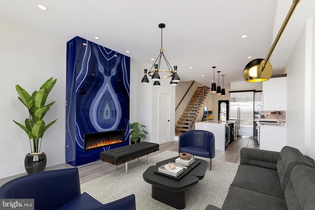 living area with light wood finished floors, stairs, and recessed lighting