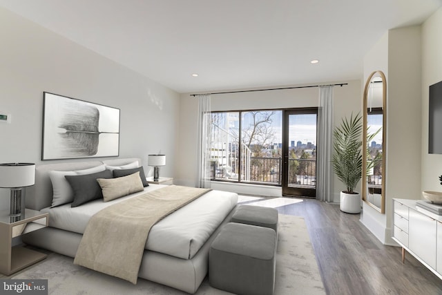 bedroom with recessed lighting, wood finished floors, and baseboards
