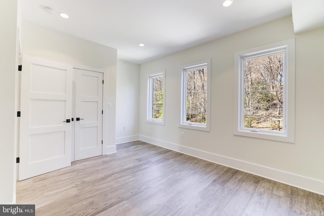 unfurnished bedroom featuring a closet, recessed lighting, light wood finished floors, and baseboards