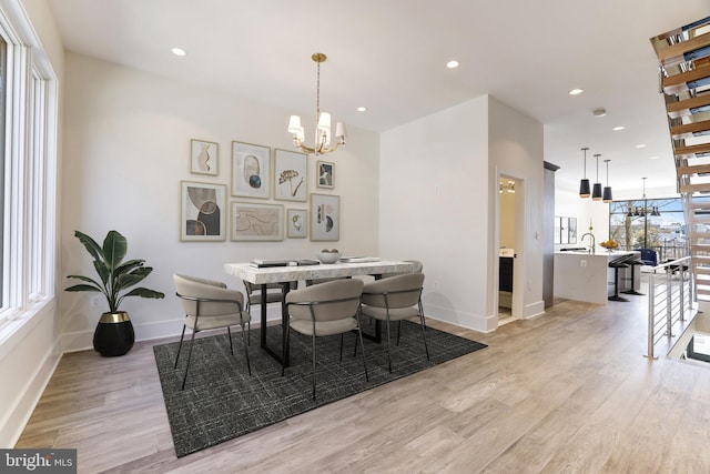 dining area with a chandelier, recessed lighting, baseboards, and light wood-style floors