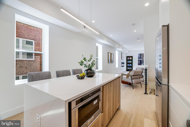kitchen with stainless steel appliances, light wood-style flooring, recessed lighting, modern cabinets, and a kitchen island