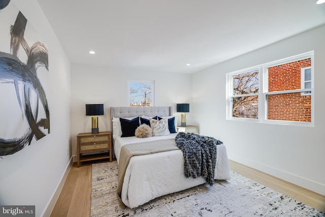 bedroom with baseboards, wood finished floors, and recessed lighting