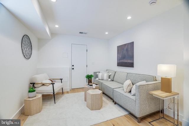 living area featuring visible vents, baseboards, wood finished floors, and recessed lighting