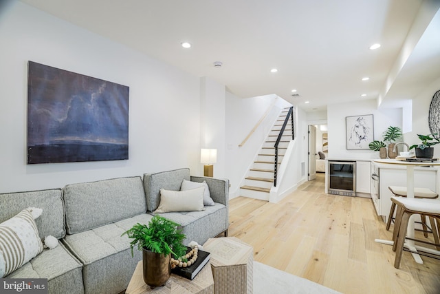 living room with light wood finished floors, wine cooler, baseboards, recessed lighting, and stairs