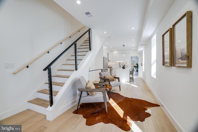stairway with visible vents, baseboards, wood finished floors, and recessed lighting