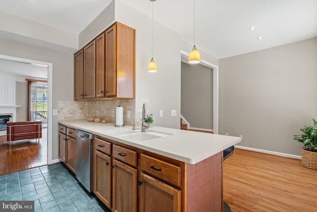 kitchen featuring a sink, decorative backsplash, dishwasher, and light countertops