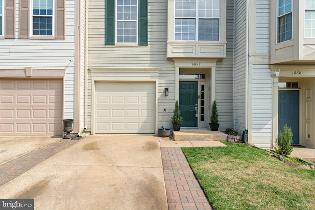 property entrance featuring an attached garage and driveway