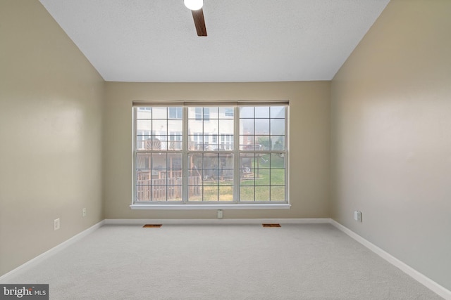 spare room with carpet floors, ceiling fan, baseboards, and a wealth of natural light