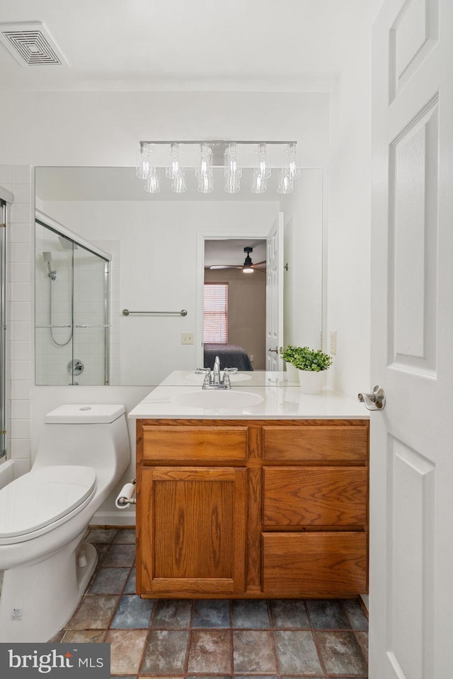 bathroom featuring a shower with shower door, vanity, ensuite bath, toilet, and visible vents