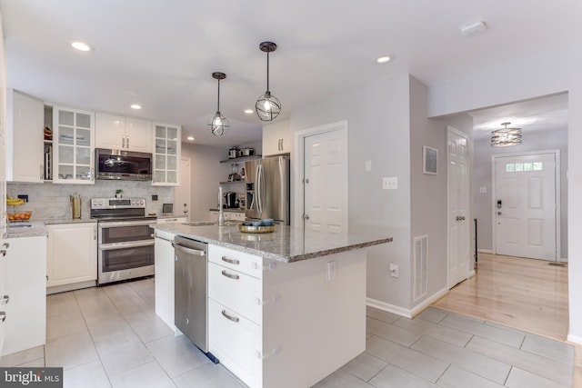 4011 Hummer Rd, Annandale, VA 22003 - kitchen with stainless steel appliances, a sink, white cabinets, a center island with sink, and recessed lighting