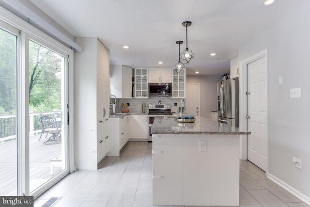 4011 Hummer Rd, Annandale, VA 22003 - kitchen featuring appliances with stainless steel finishes, a sink, tasteful backsplash, a center island, and light stone counters