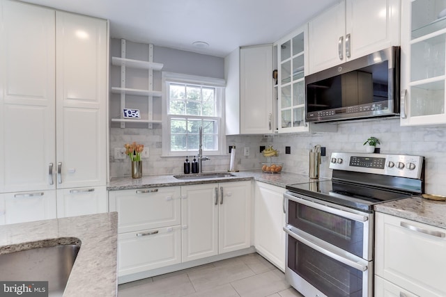 4011 Hummer Rd, Annandale, VA 22003 - kitchen featuring stainless steel appliances, a sink, white cabinetry, decorative backsplash, and light tile patterned floors