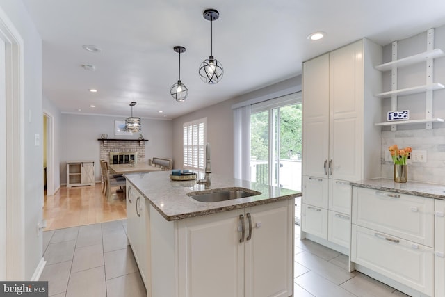 4011 Hummer Rd, Annandale, VA 22003 - kitchen with a sink, light tile patterned flooring, a brick fireplace, recessed lighting, and a kitchen island with sink