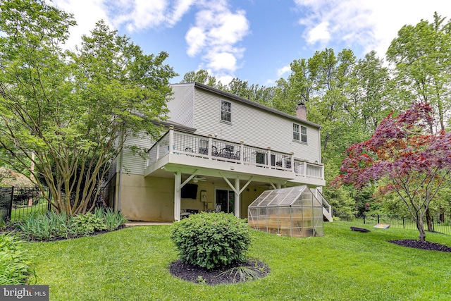 4011 Hummer Rd, Annandale, VA 22003 - rear view of house featuring a greenhouse, a chimney, a wooden deck, and an outbuilding