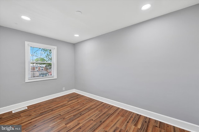 spare room with visible vents, recessed lighting, baseboards, and wood finished floors