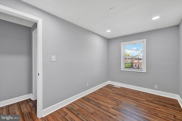 empty room featuring baseboards, recessed lighting, wood finished floors, and visible vents