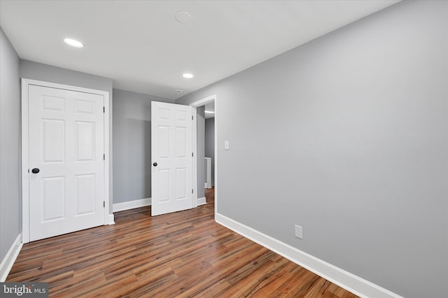 unfurnished bedroom featuring baseboards, recessed lighting, and wood finished floors