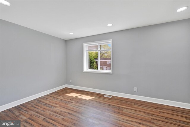 spare room with visible vents, recessed lighting, baseboards, and wood finished floors