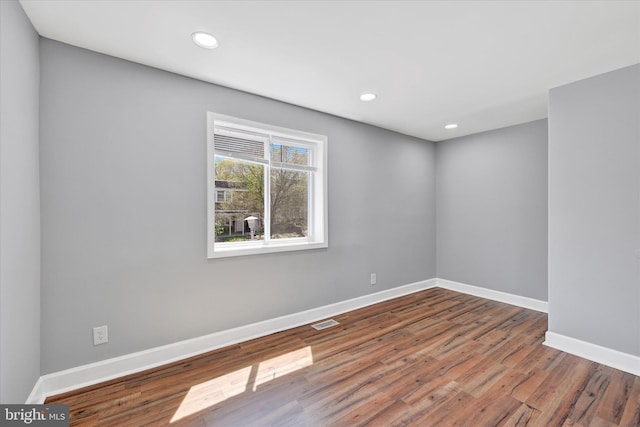spare room featuring baseboards, recessed lighting, wood finished floors, and visible vents