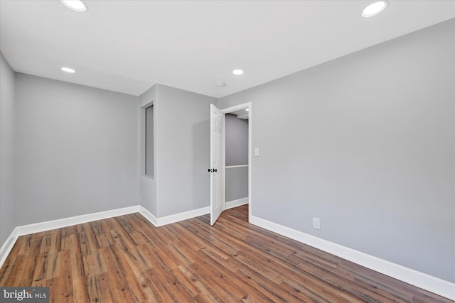 empty room with baseboards, recessed lighting, and wood finished floors