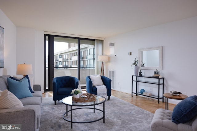 living area with visible vents, baseboards, and wood finished floors