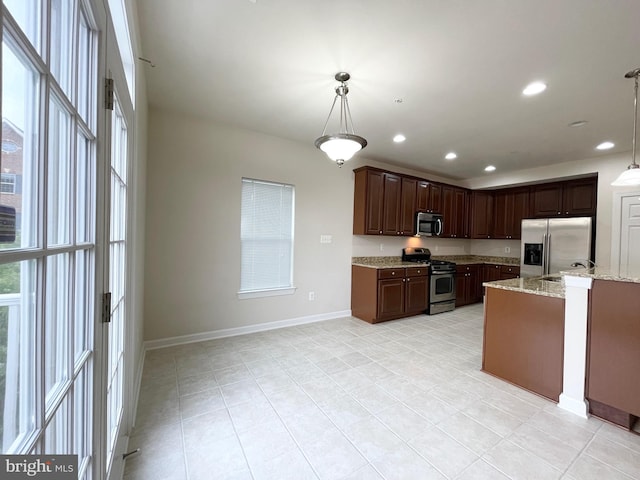 3648 Holborn Pl Unit 3648, Frederick, MD 21704 - kitchen with light tile patterned floors, light stone countertops, baseboards, hanging light fixtures, and appliances with stainless steel finishes