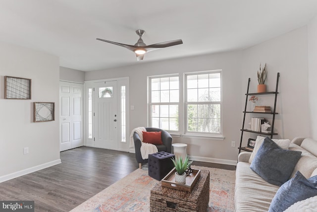 living area featuring baseboards, a ceiling fan, and wood finished floors