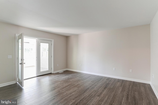 unfurnished room with baseboards and dark wood-type flooring