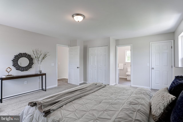 bedroom featuring carpet flooring, a closet, baseboards, and ensuite bath