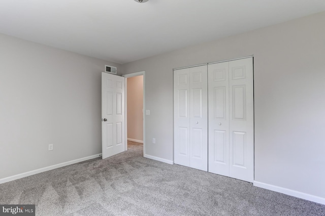 unfurnished bedroom featuring carpet floors, baseboards, visible vents, and a closet