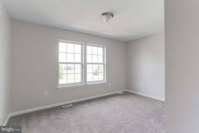unfurnished room with baseboards, carpet, and visible vents