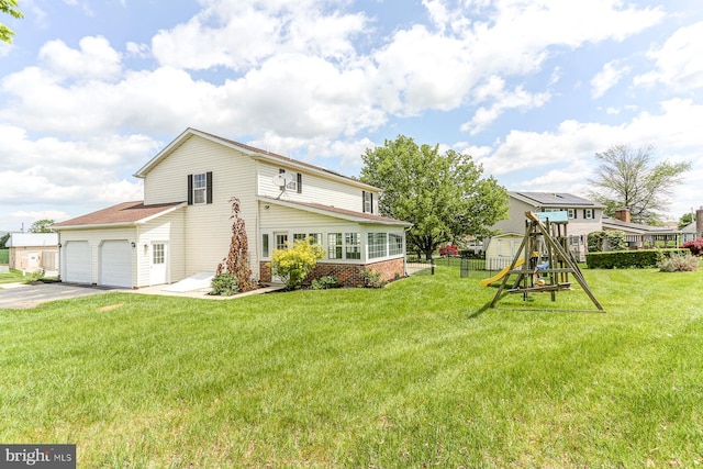 rear view of property with a garage, fence, a playground, concrete driveway, and a yard