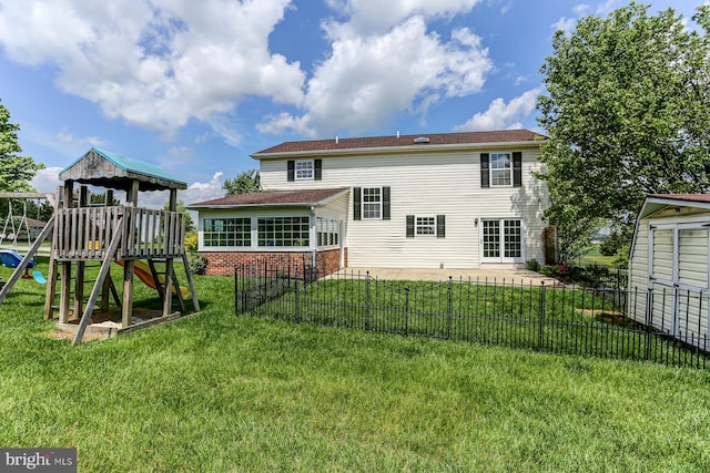 back of property with fence, brick siding, a patio area, a playground, and a lawn