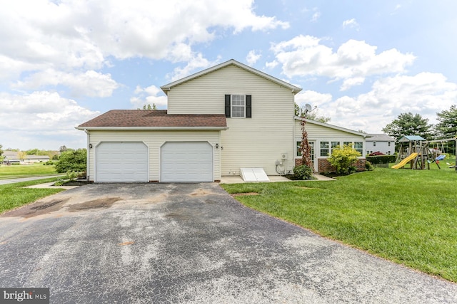 view of side of home with a garage, a playground, a yard, and driveway