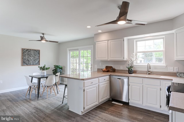 kitchen with white cabinets, ceiling fan, a sink, stainless steel appliances, and a peninsula