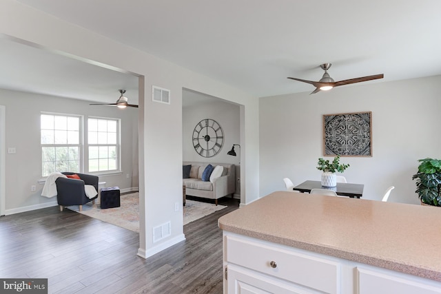 kitchen with ceiling fan, visible vents, light countertops, white cabinets, and open floor plan