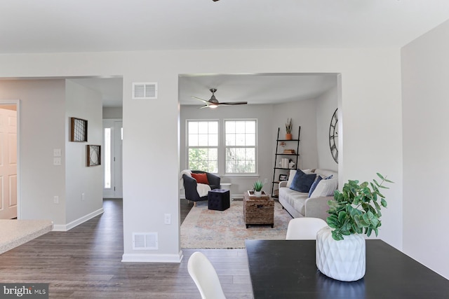 living room with visible vents, dark wood-style flooring, ceiling fan, and baseboards