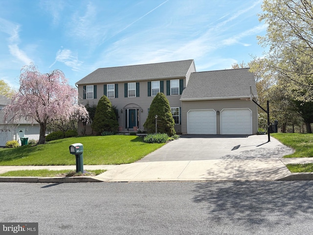 colonial home with a front yard, driveway, an attached garage, and roof with shingles