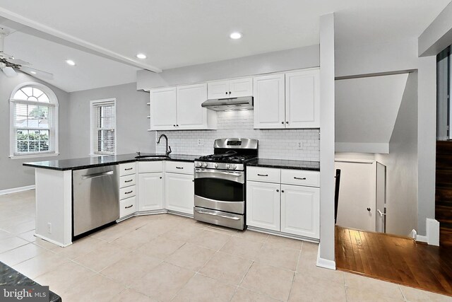 4500 Hadrian Ct, Alexandria, VA 22310 - kitchen featuring stainless steel appliances, a sink, a peninsula, white cabinets, and lofted ceiling