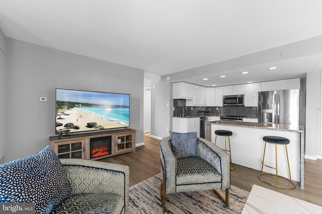 living area with baseboards and wood finished floors
